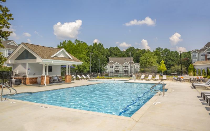 a swimming pool with buildings and trees behind it