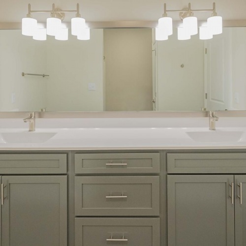 Settle into comfort at Cambridge Apartments a bathroom with a large mirror